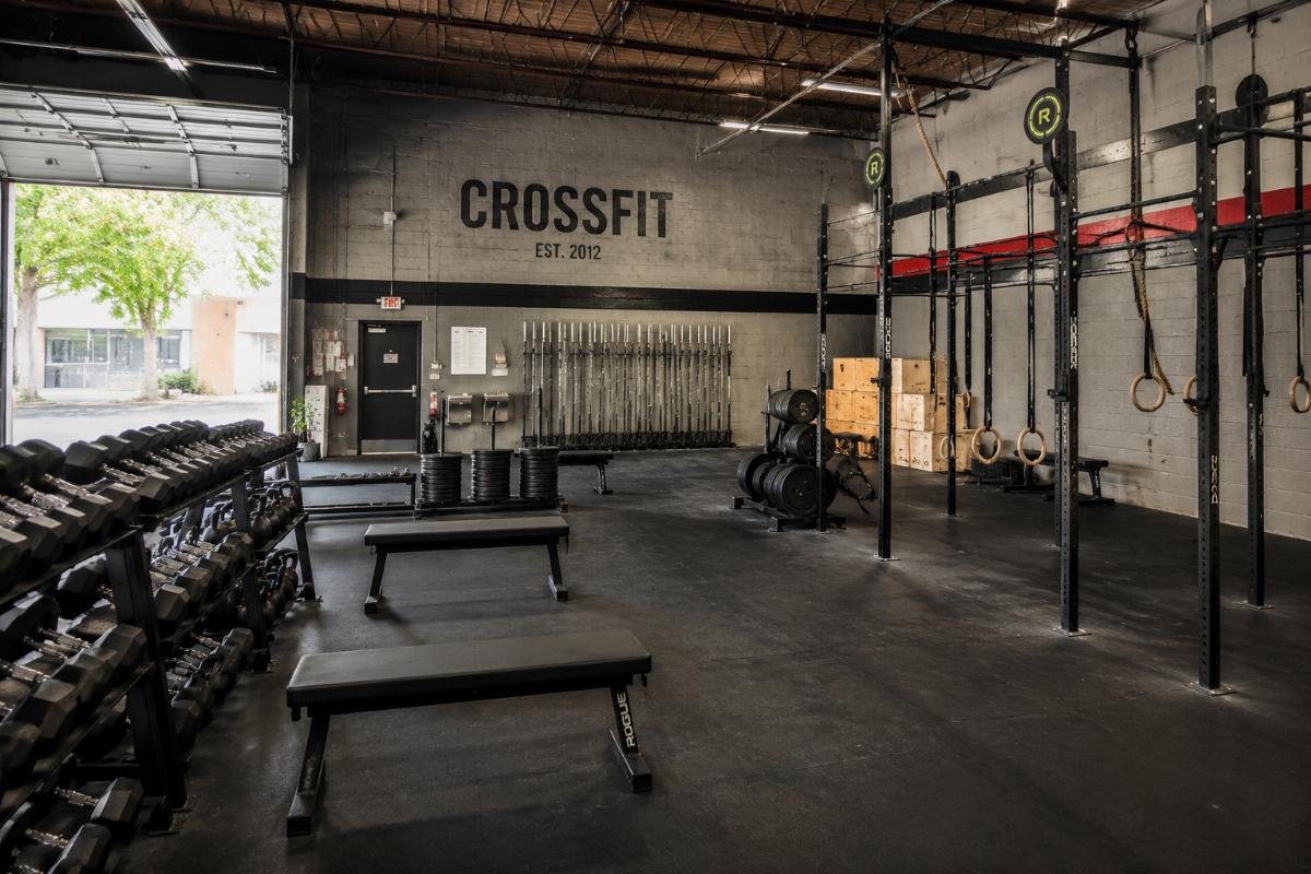 warehouse CrossFit gym equipment configuration Free weight equipment arranged in a converted CrossFit warehouse space